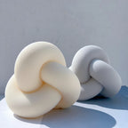 Cream and gray ribbed knot candles side by side