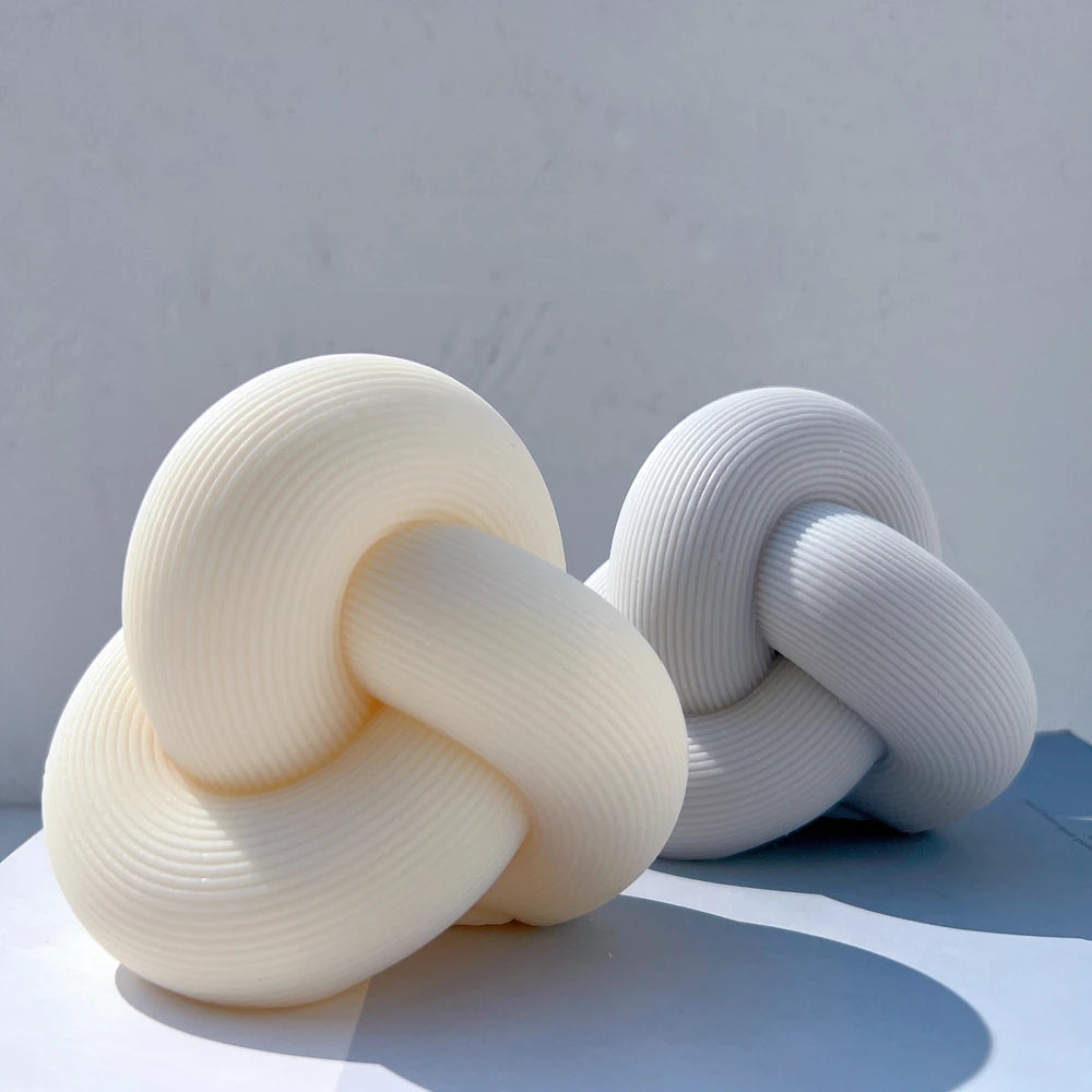Cream and gray ribbed knot candles side by side