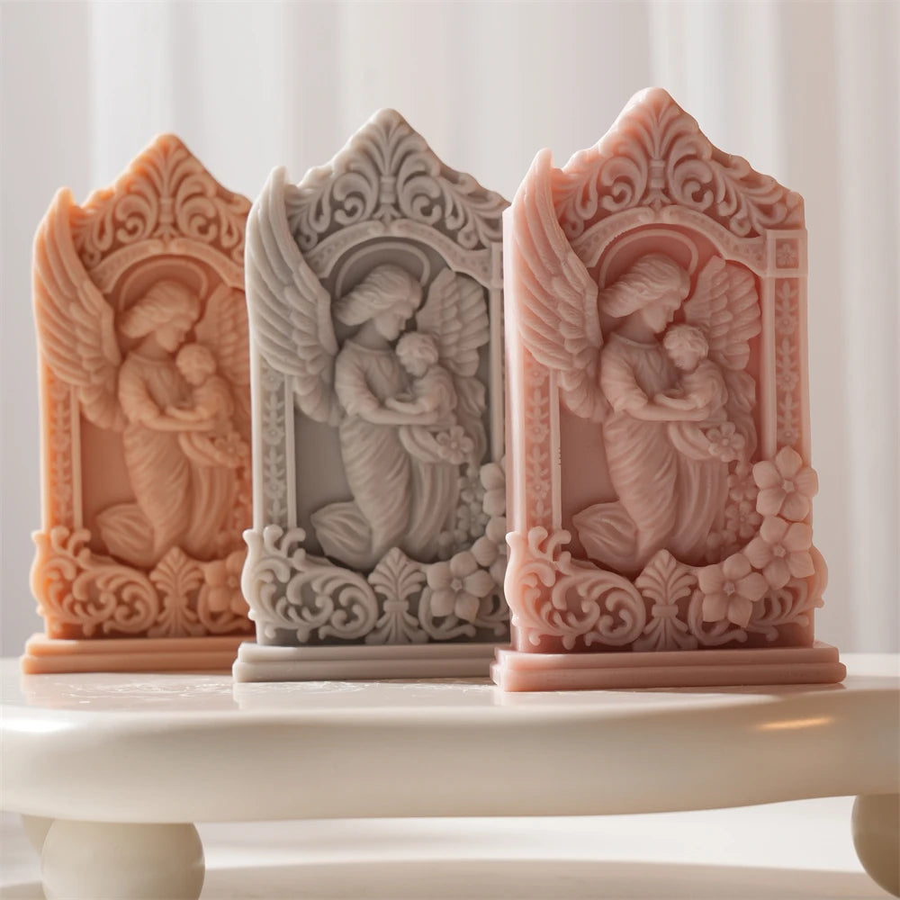 Three front-facing mother-and-baby angel plaques