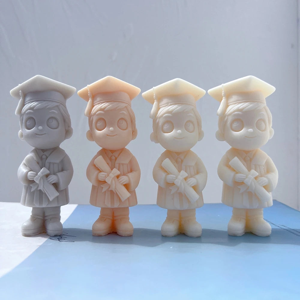 Boy graduate candle castings with glasses and diplomas
