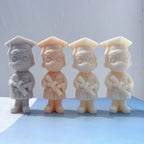 Boy graduate candle castings with glasses and diplomas