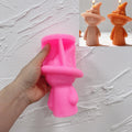 Pink textured-witch silicone candle mold held in one hand