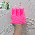 Pink scrollwork gift sleigh silicone mold held in one hand