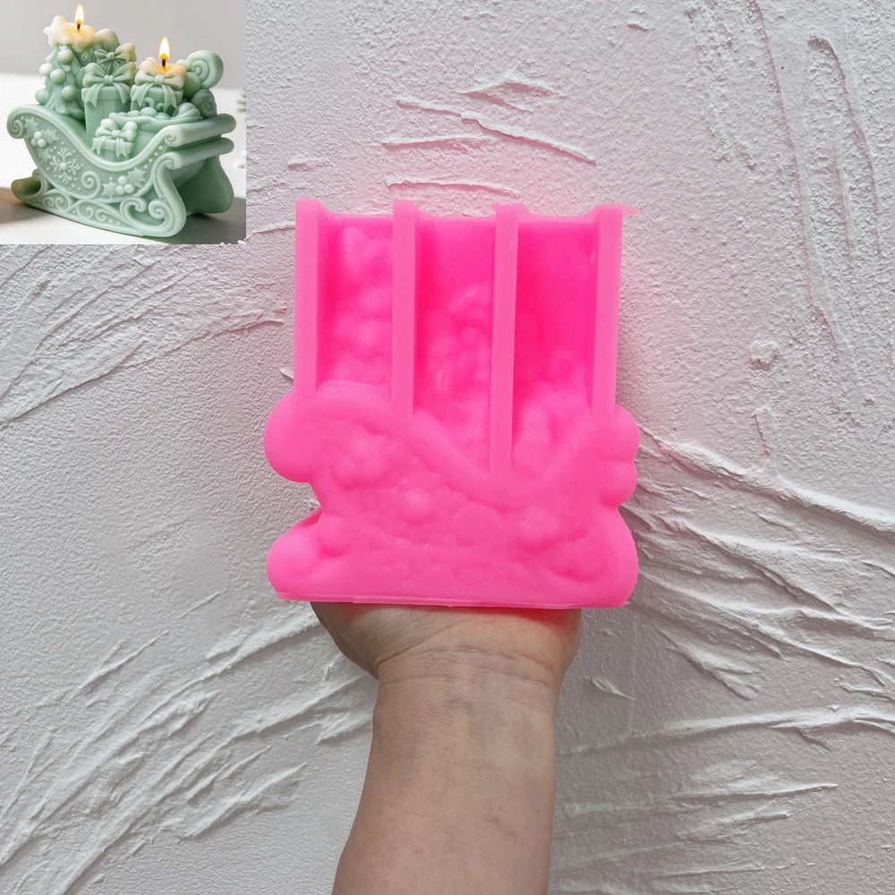 Pink scrollwork gift sleigh silicone mold held in one hand