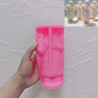Pink long-coat Santa silicone candle mold held in one hand