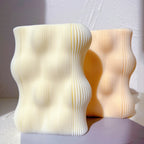 Ivory and peach rectangular candles with rounded wave contours