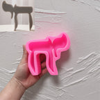 Pink silicone mold showing cutouts and contours of the Hebrew Chai letters