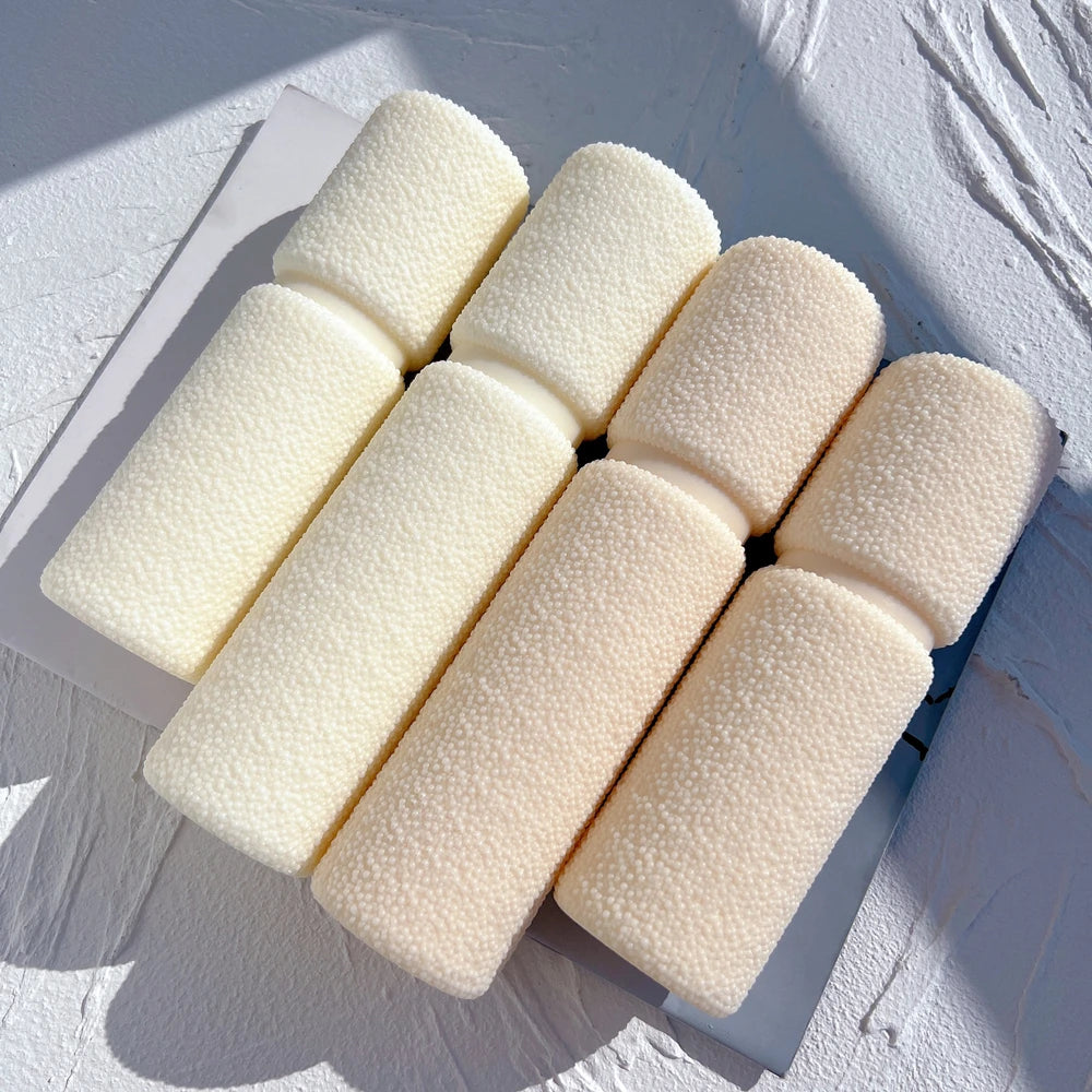 Textured waisted pillars laid flat to show their rounded ends