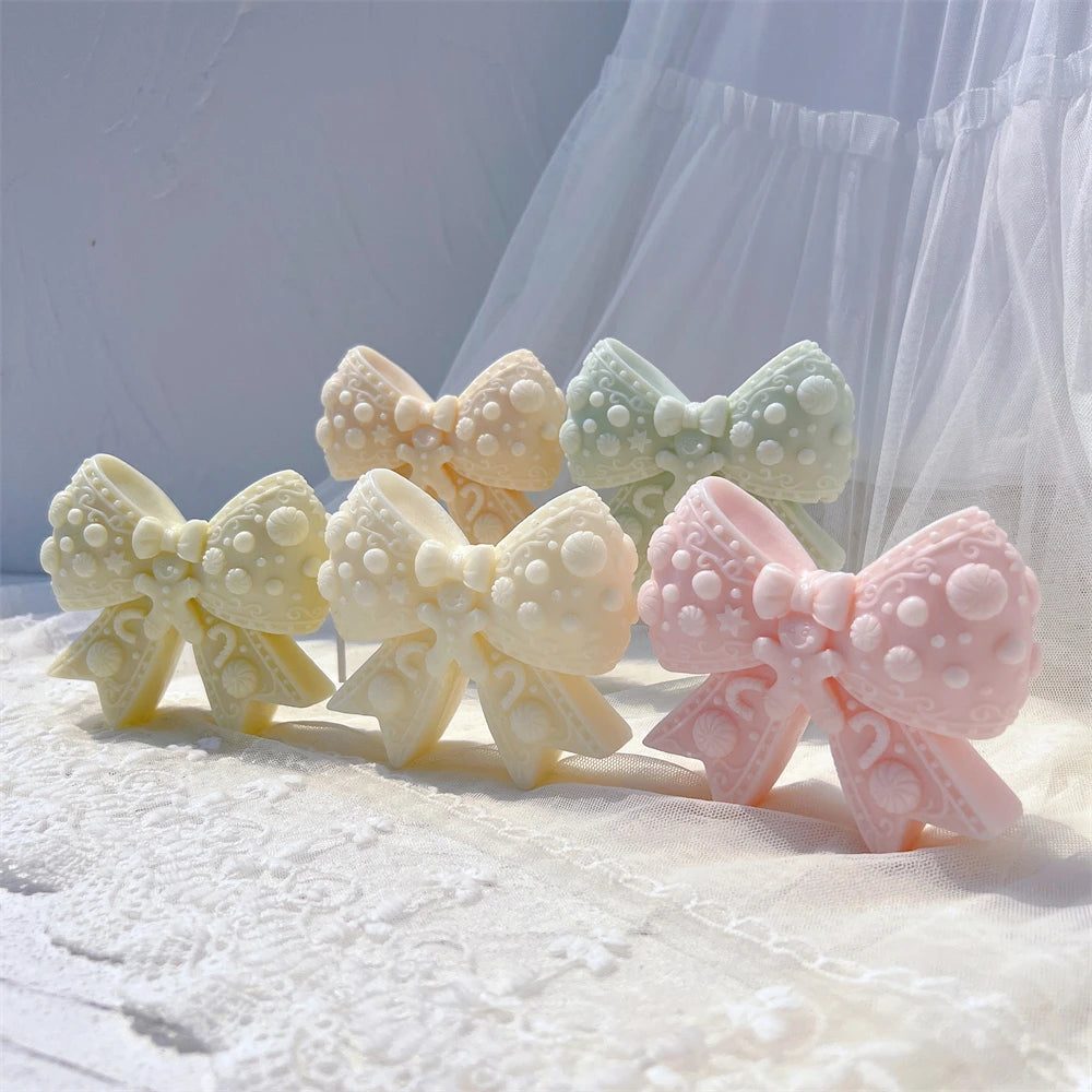 Pastel decorated bow candle castings with gingerbread-style motifs