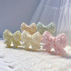 Pastel decorated bow candle castings with gingerbread-style motifs