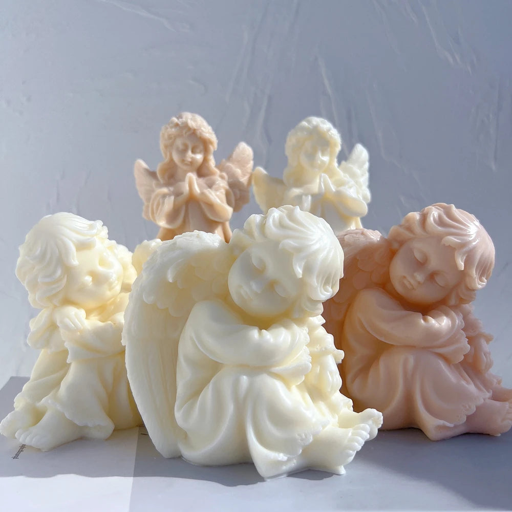 Two seated cherub castings in front of standing angel figurines