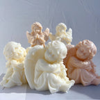 Two seated cherub castings in front of standing angel figurines