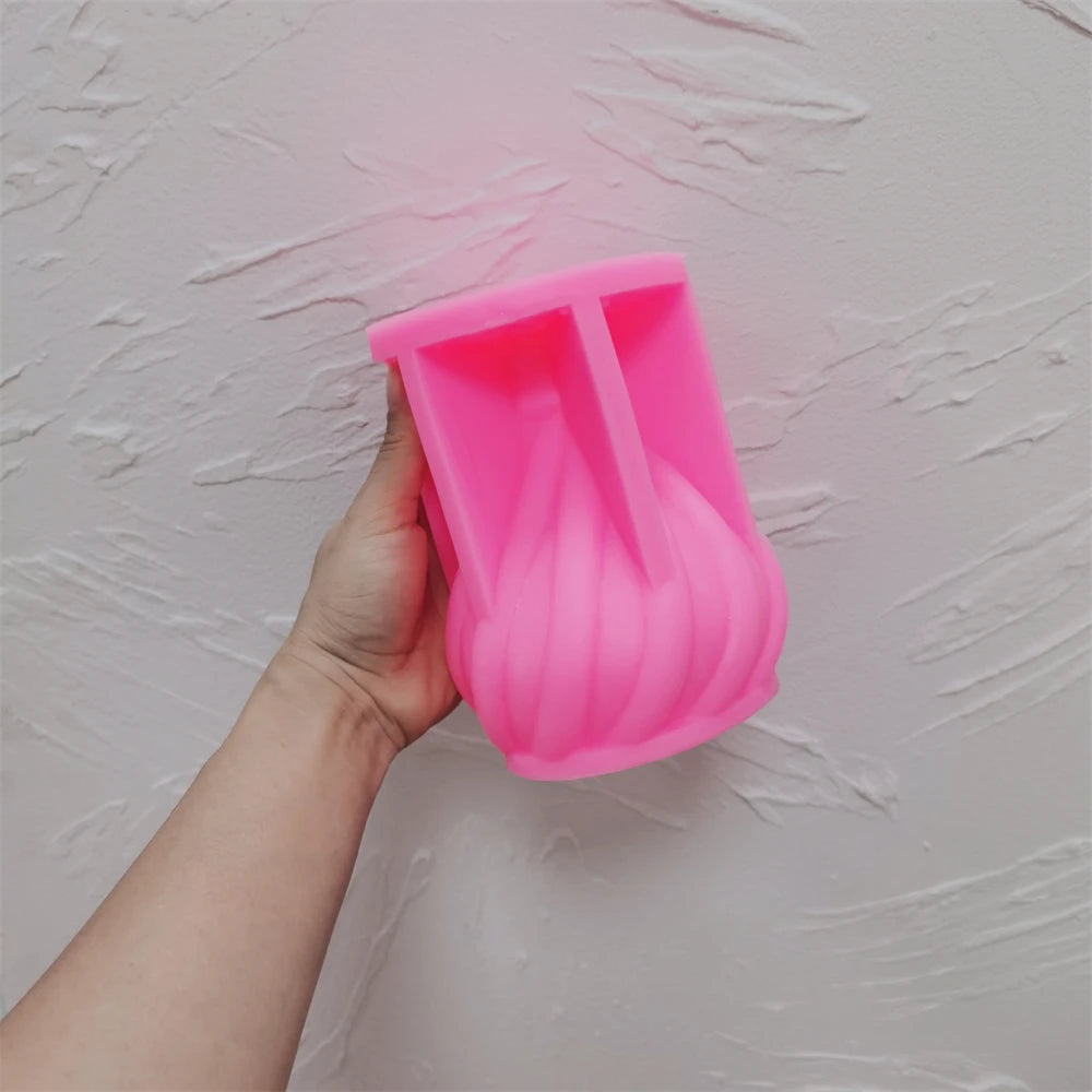 Pink spiral droplet silicone mold held open beside a wall
