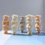 Graduation boy and girl candle figures wearing mortarboards