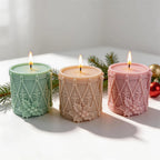 Three Christmas drum candles with decorative relief panels
