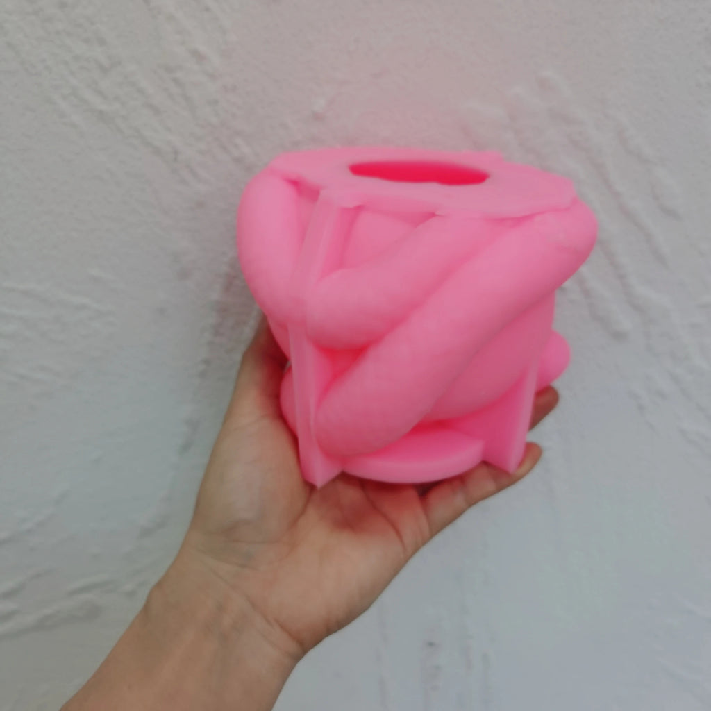 Pink snake-coiled apple silicone mold held in one hand