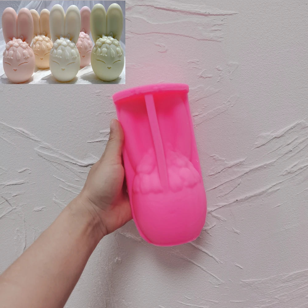 Pink silicone bunny egg mold held beside finished candle examples