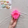 Pink silicone mold for layered poinsettia flower held in a hand