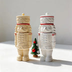 Two decorative nutcracker soldier lidded vessel castings in ivory and white