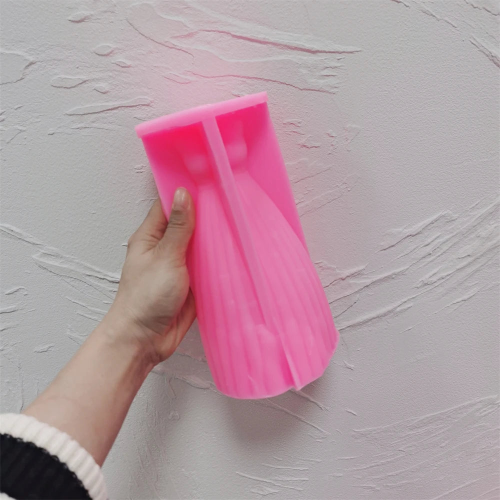 Pink silicone gown mold held to show its pleated skirt cavity
