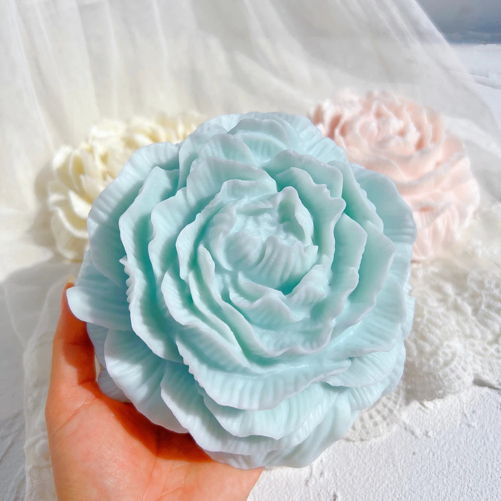 Blue peony casting held in a hand to show its petal layers