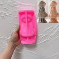 Pink silicone mold for the braided flower girl figure held in a hand