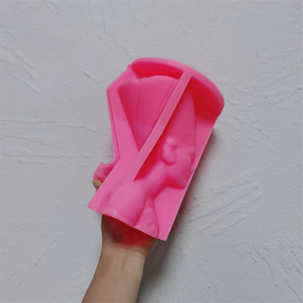 Pink Nefertiti-style bust silicone mold held in one hand