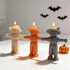 Three standing scarecrow candles beside decorative wall bats