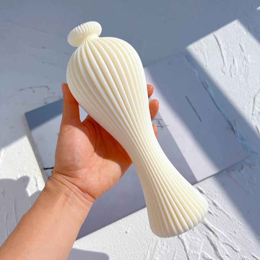 Tall ribbed vase-shaped casting held to show its narrow waist