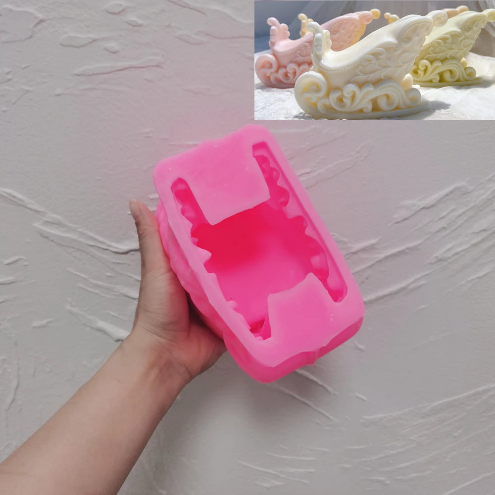 Pink silicone Christmas sleigh mold held in hand with finished casting examples