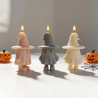 Peach gray and cream witch-hat ghosts beside Halloween props
