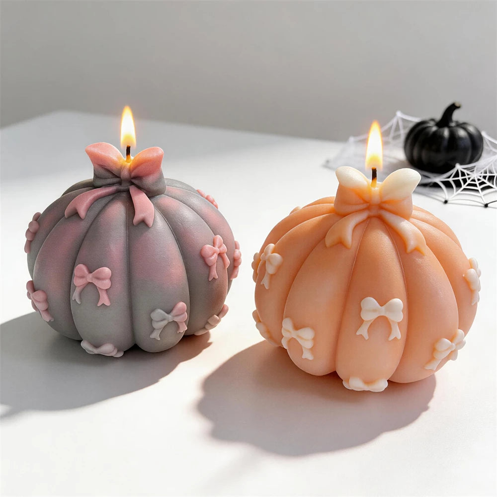 Pair of bow-covered pumpkin candle castings
