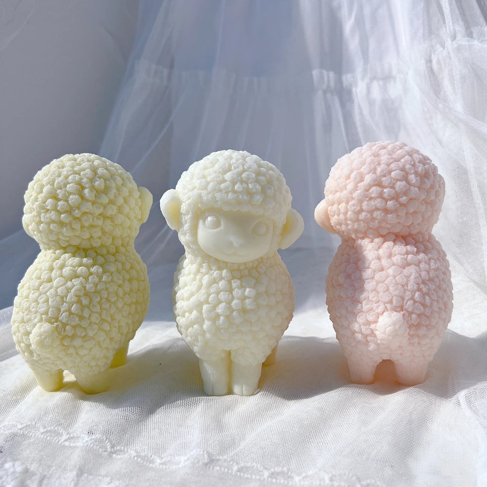 Rear of pink lamb beside front-facing cream and green castings