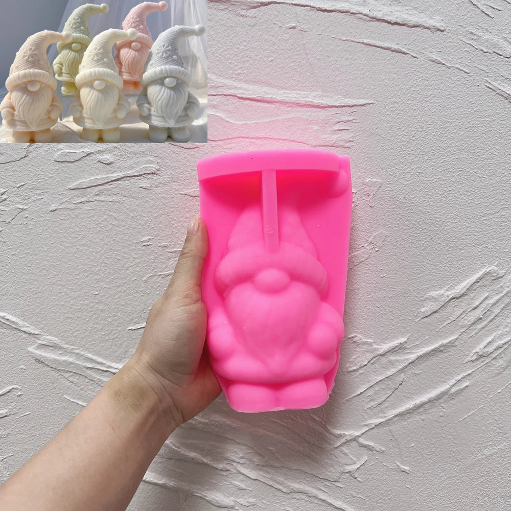 Pink Star Hat gnome mold held in a hand beside finished samples