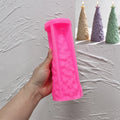 Pink silicone star topped fir tree mold held in a hand