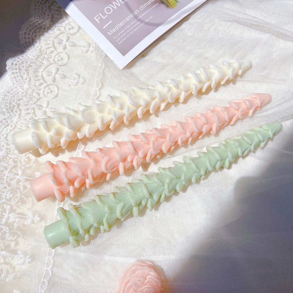 Layered slender tree candles laid on a decorative surface