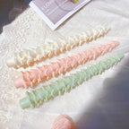 Layered slender tree candles laid on a decorative surface