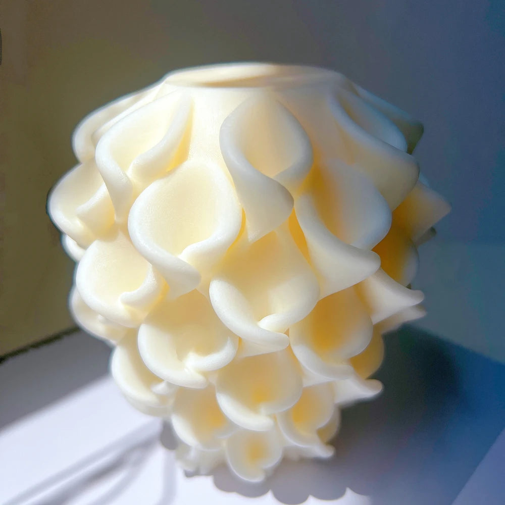 Close side view of white petal sculpture candle showing curved raised edges