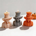 Three top hat skeleton candle samples arranged on a stone slab