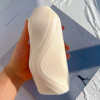 Cream flowing-wave casting held in one hand