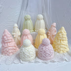 Geometric and cable-knit hat samples in a mixed Christmas figurine display