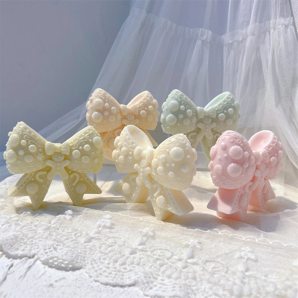 Five bow castings showing raised dots and ribbon tails
