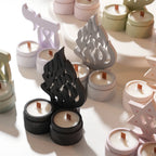 Collection of cast decorative motifs and paired-cup forms with candles for display
