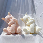 Pink and ivory cat figures with pointed ears and spread hind paws