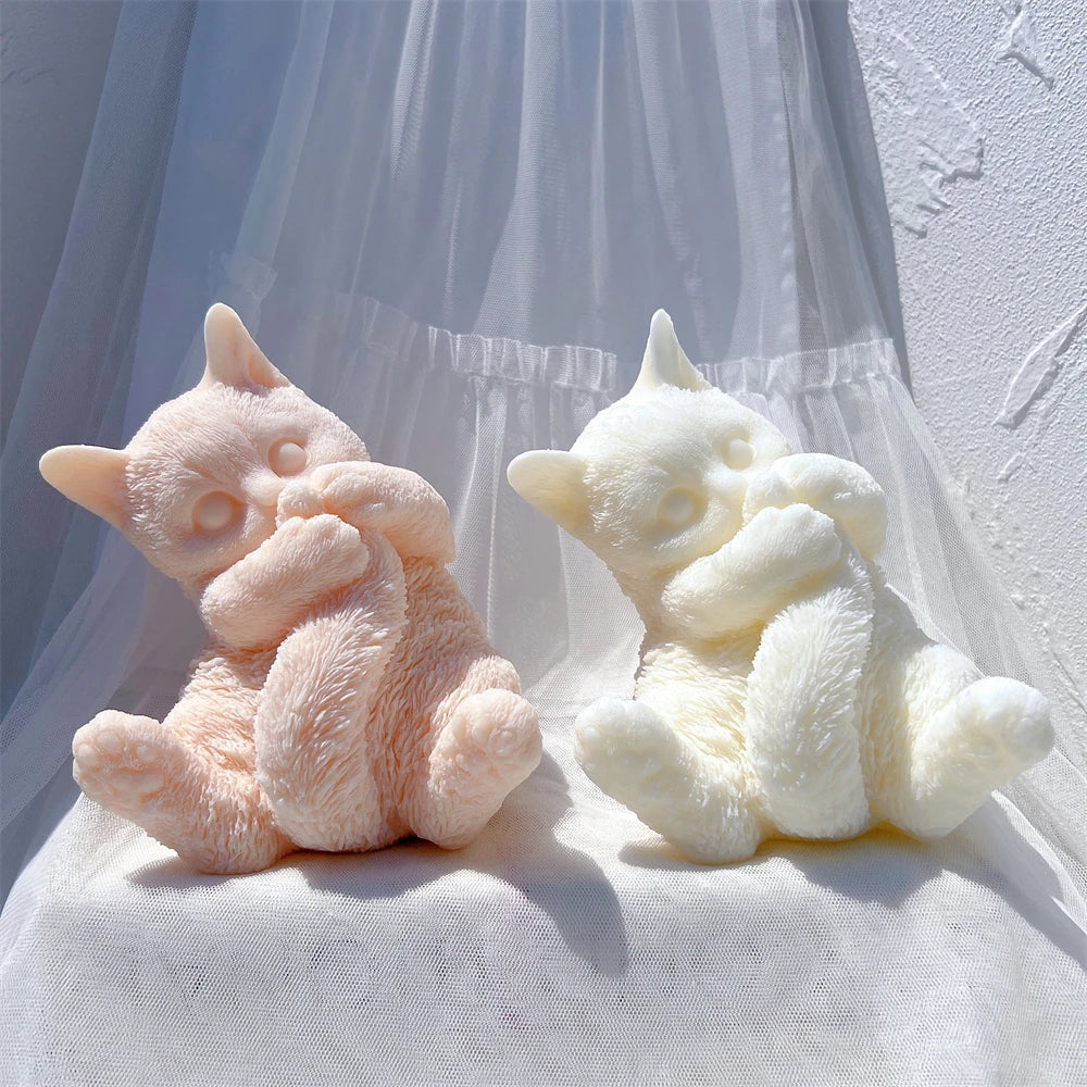 Pink and ivory cat figures with pointed ears and spread hind paws
