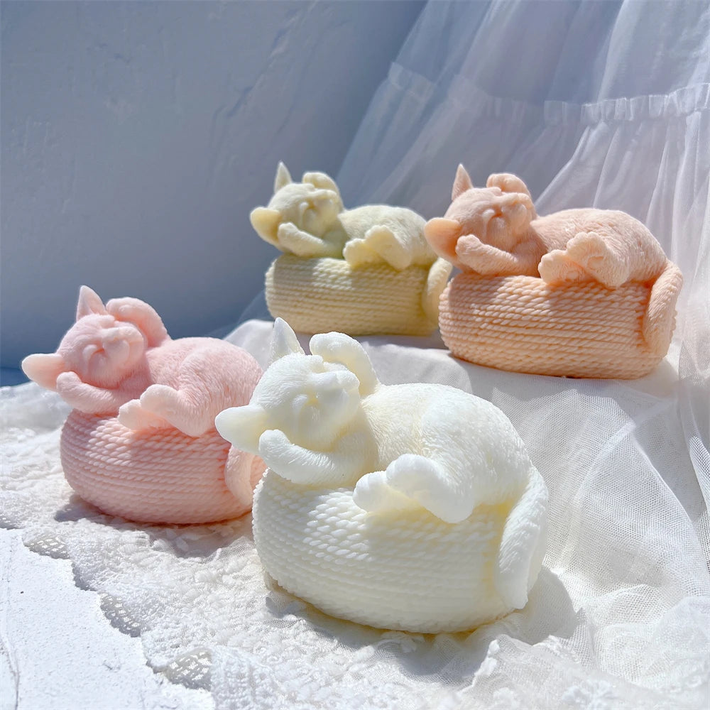 Four pastel cat-and-basket castings with tucked paws