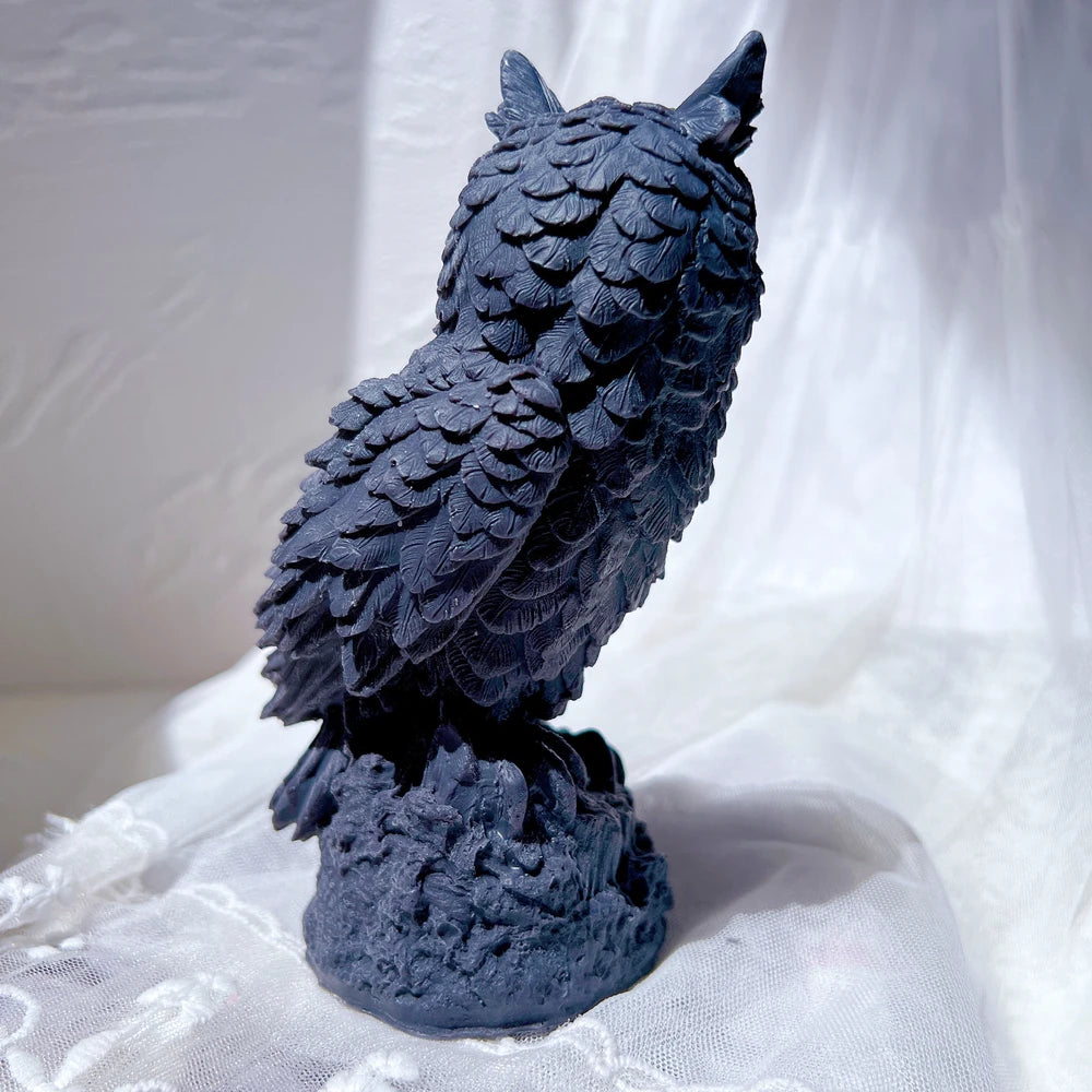 Rear view of dark owl casting with overlapping wing feathers