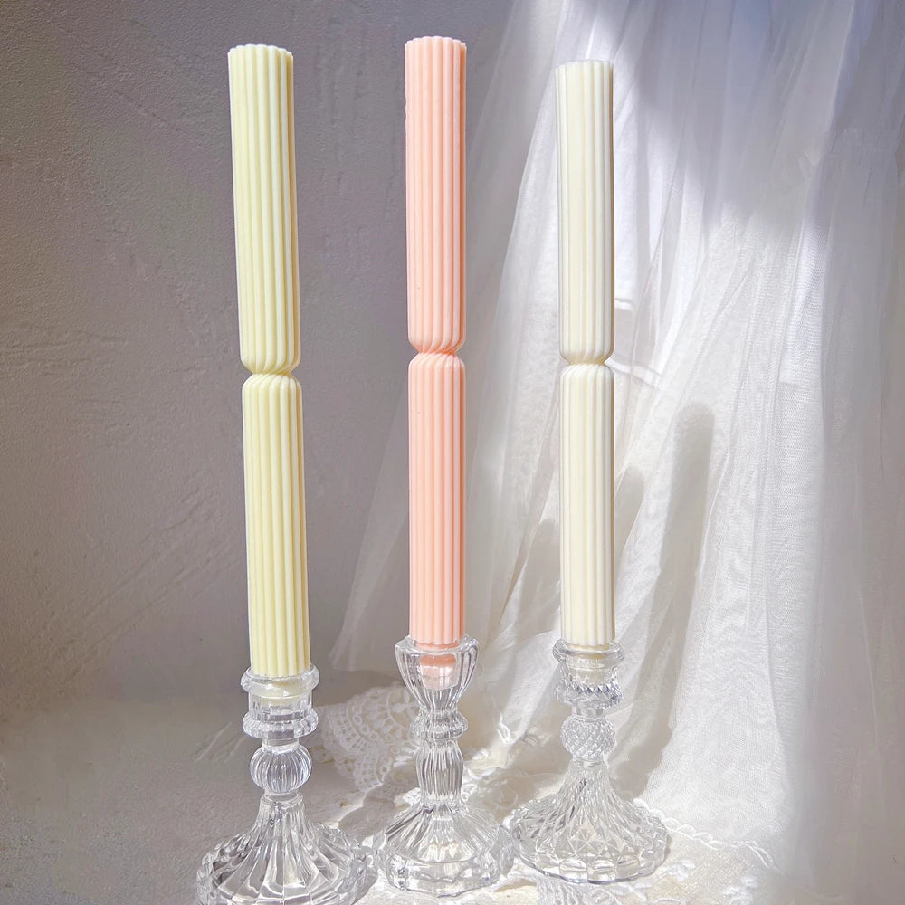 Two slender ribbed taper castings with smooth lower feet