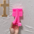 Pink Straight + Base cross silicone mold beside a gold casting