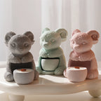 Gray, mint and pink seated ram holders shown with round candle cups